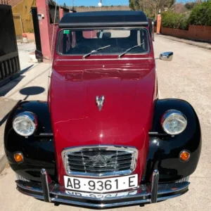 Restauración de vehículos: coche clásico rojo de frente con acabado restaurado y detalles cuidados